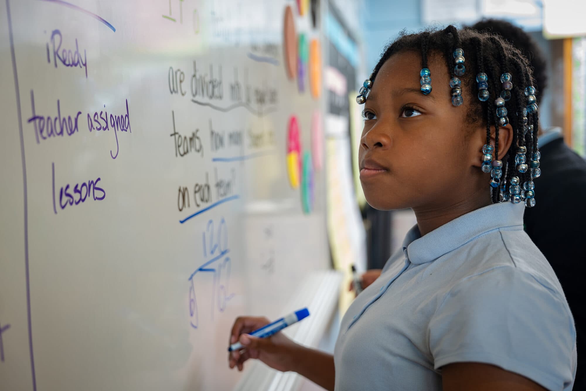 An FLI student working at the classroom whiteboard.